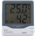 A digital humidity and temperature monitor with a gray body and black digital display showing temperature and humidity levels.